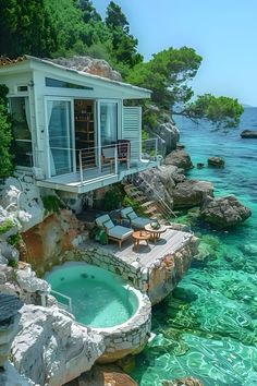 an outdoor hot tub in the middle of some clear blue water next to a house