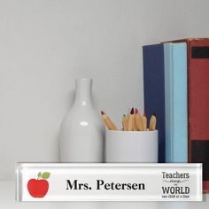 there is a teacher's desk with books and pencils