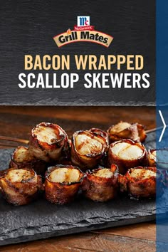 grilled bacon wrapped scallop skewers on a black slate platter