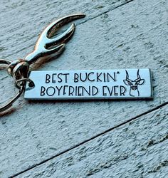 a metal keychain with the words best buckin'boyfriend ever on it