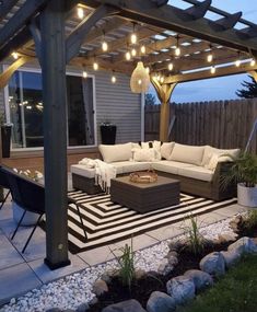 an outdoor living area with patio furniture and string lights on the pergolated roof