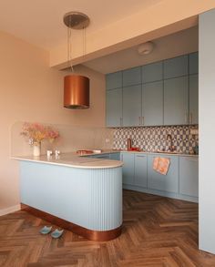 a kitchen with blue cabinets and wooden floors