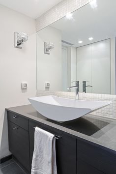 a bathroom with a sink, mirror and towel hanging on the wall next to it