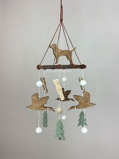 a mobile made out of wood with birds and trees hanging from it