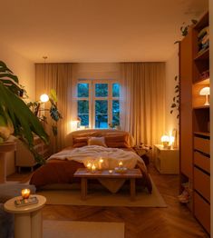 a bed room with a neatly made bed and candles on the table next to it