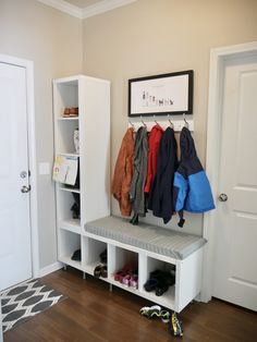 a coat rack with coats hanging on it and shoes sitting on the floor next to it