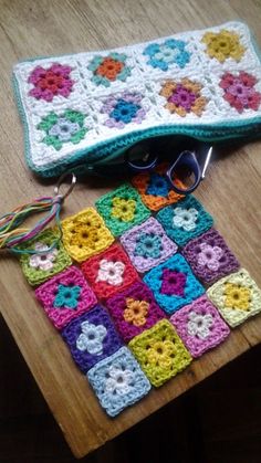 a crocheted granny blanket and sunglasses on a table