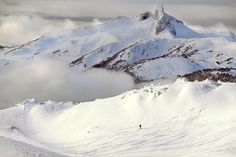 a person on skis is standing in the snow with mountains in the back ground