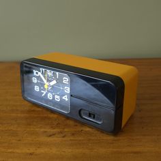 an alarm clock sitting on top of a wooden table