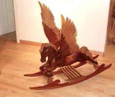 a wooden rocking horse with wings on it's back