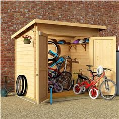 a wooden storage shed with bicycles in it