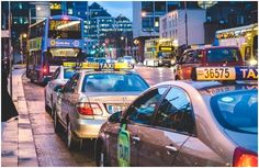 a busy city street filled with lots of traffic and tall buildings in the background at night