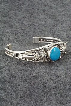 This turquoise and sterling silver bracelet was made by Navajo silversmith Raymond Delgarito. The inside is signed RD and stamped sterling.Size: 5 1/2" (will fit up to a 6 3/4" wrist)Gap: 1 1/4"Width: 3/4" tapered to 1/4"Free shipping on all orders! We ship with USPS and always include tracking. All orders ship within a day of payment.Returns are accepted up to 30 days after you receive your order. Just send us a message. Our shop offers cash back or store credit. The item must be returned in ne Adjustable Southwestern Sterling Silver Bracelet With Turquoise, Adjustable Southwestern Turquoise Sterling Silver Bracelet, Adjustable Turquoise Sterling Silver Bracelet In Southwestern Style, Stamped Turquoise Sterling Silver Bracelet, Stamped Sterling Silver Bracelet In Turquoise, Sterling Silver Turquoise Stamped Bracelet, Western Style Blue Sterling Silver Bracelet Gift, Southwestern Sterling Silver Cuff Bracelet In Blue, Southwestern Style Turquoise Bracelet Stamped 925