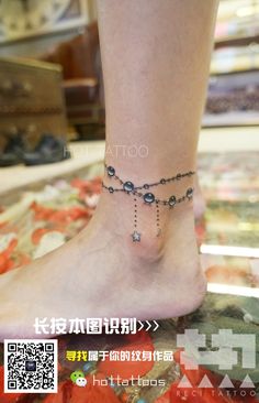 a woman's foot with a chain ankle bracelet on it, and the words tattoo written