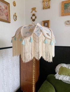 a lamp that is sitting on top of a wooden stand next to a green chair