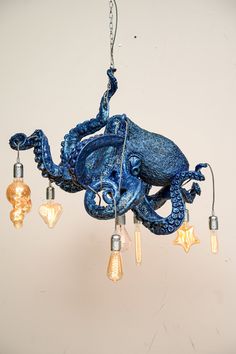 an octopus chandelier hanging from the ceiling with five bulbs on it's side