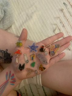 a person's hand with lots of stickers on it and tattoos on the palm