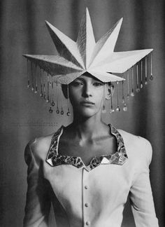 a black and white photo of a woman with a paper hat on top of her head