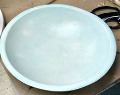 a blue bowl sitting on top of a cardboard box next to scissors and pliers