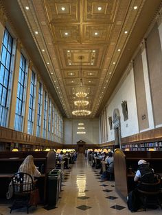 people are sitting at tables in the library