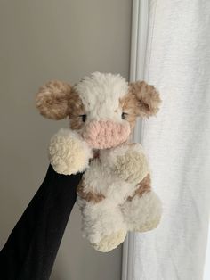 a person holding a stuffed animal in their hand