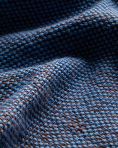 the texture of a blue and brown knitted fabric is shown in close up view