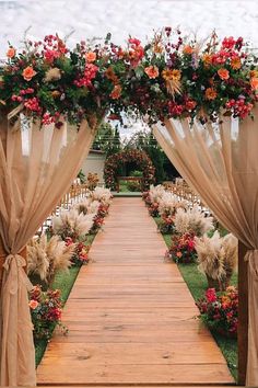 an outdoor wedding ceremony with flowers and drapes