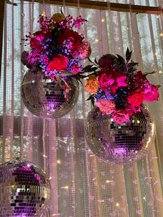 two disco ball vases with flowers in them