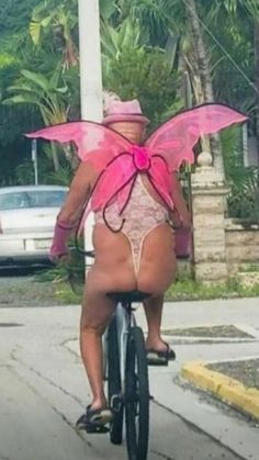 a person riding a bike with a pink butterfly on it's back and legs