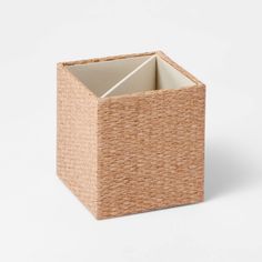 an empty basket on a white surface with the lid open and it's bottom half closed