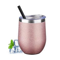 a pink tumbler with a straw in it next to ice cubes and mint