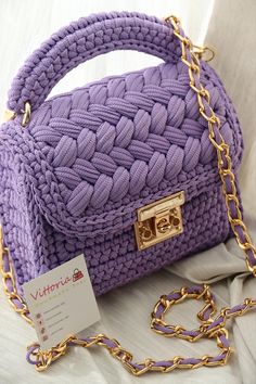 a purple handbag with a gold chain around it