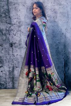 This exquisite regal paithani saree is handwoven in bluish purple color. Silver zari dollar buttis adorn the body while the silver zari border is decorated with handwoven in muniya border. The elaborate pallu is woven with colorful lotus along with winding vines. The saree comes with plain blouse with matching borders. Approximate Length 6.5 mtrs (inclusive of blouse length)Height - 48- 52" Saree comes with fall, picot and tassels done. Blouse piece is cut. Approximate weight - 1.8 lbs Kindly Note : The colors you see on your device may vary due to the color reproduction, brightness and resolution of individual devices. If you'd like more clarity before your purchase, please contact our support team. Paithani Silk Saree, Bluish Purple, Paithani Saree, Plain Blouse, Saree Trends, Blouse Length, Support Team, Cotton Saree, Blouse Piece