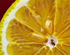 an orange cut in half on a red surface