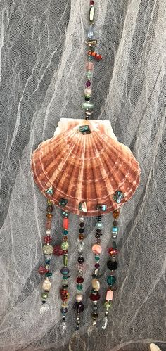 a shell with beads hanging from it's side