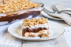 a piece of dessert sitting on top of a white plate next to a pan of food