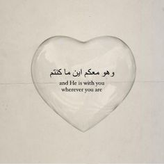 a heart shaped object with an arabic quote on it's side, in front of a white wall