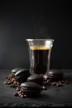 chocolate cookies and coffee on a table with beans around the cup in the dark background