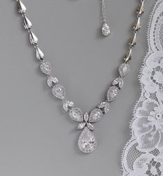 "Stunning teardrop crystal necklace has been designed with marquise cut crystals in between teardrop crystal zircons set in halos of tiny crystals creating a statement necklace in true Hollywood style. The upper band has been made with coordinating shell shaped links to create a comfortable and light necklace to wear. An 1.5\" extender chain with a pretty crystal drop is optional. Measures: L = 17\" (43 cm) approx High quality zircon crystals set in tarnish free rhodium. Highest quality cubic zi Pear-shaped Crystal Necklaces With Diamond Accents, Teardrop Drop Necklace With Sparkling Stones, Wedding Teardrop Diamond Necklace, Teardrop Diamond Necklace With Sparkling Stones, Cubic Zirconia Teardrop Pendant Necklace With Sparkling Stones, Wedding Diamond Teardrop Necklace With Sparkling Stones, Wedding Diamond Necklace With Teardrop Sparkling Stones, Crystal Teardrop Pendant Drop Necklace With Sparkling Stones, White Crystal Teardrop Drop Necklace