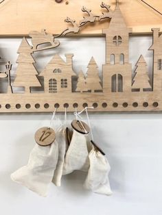 two wooden ornaments hang on a coat rack with clothes hanging from it's hooks