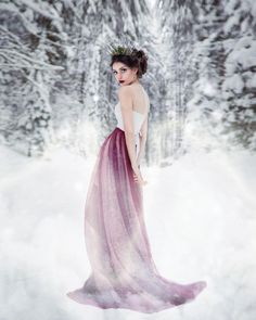 a woman is standing in the snow wearing a dress