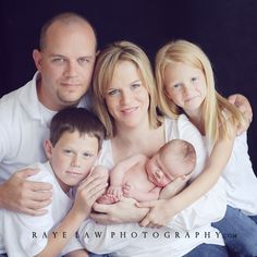 a family poses for a photo with their newborn baby