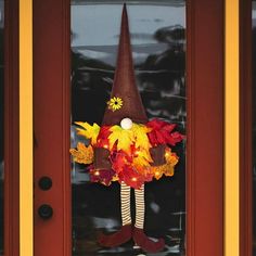 a door with a wreath on it and a witch's hat hanging from the front