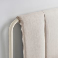 a close up of a bed with two pillows on top of it and a white headboard