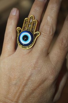 "Gorgeously beautiful, unique and one of a kind large Hamsa evil eye adjustable ring in antique gold or Tibetan silver. Size over 1 1/2\". Since the Hamsa is considered a gift of love it makes it the perfect gift. For those of you who are not familiar with the Hamsa, well, it's a symbol that's been around for thousands of years and is believed to protect and shield against the evil eye, generate positive energy, provide good fortune, health, prosperity and happiness. CUSTOM ORDERS WELCOME DELIVE Symbolic Evil Eye Jewelry Ring, Symbolic Evil Eye Ring Jewelry, Spiritual Evil Eye Ring Jewelry, Bohemian Evil Eye Metal Jewelry, Adjustable Evil Eye Ring Jewelry, Bohemian Adjustable Eye-shaped Jewelry, Adjustable Bohemian Eye-shaped Jewelry, Bohemian Eye-shaped Adjustable Jewelry, Adjustable Evil Eye Open Ring Jewelry