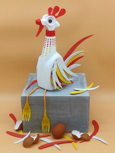 a chicken sitting on top of a box with forks