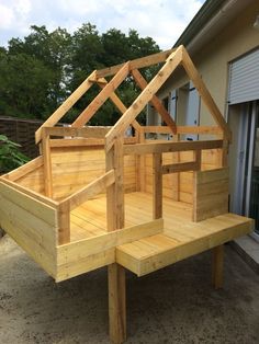 a wooden house built into the side of a building next to a patio area with benches