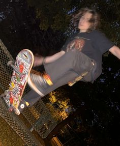 a skateboarder in mid air doing a trick on a fence with trees in the background