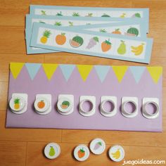 the paper is cut out and placed on the table with fruit themed tape dispensers