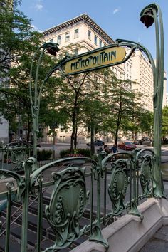 a street sign that is on top of a metal fence